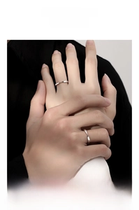 Detailed view of 925 silver Mobius rings worn by a couple holding hands in a close-up