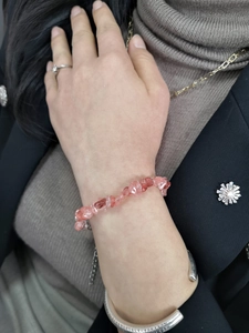 Detail of pink crystal chips bracelet worn with a silver engraved cuff on wrist