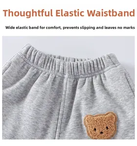 Dettaglio della vita elastica dei pantaloni grigi per bambini con toppa a forma di orso