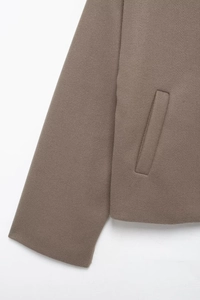 Close-up of brown wool blend jacket showing fabric texture and side pocket detail