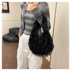 Model wearing a black faux fur shoulder bag with tassel texture and Y2K aesthetic