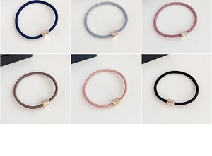 Close-up of elastic hair ties in six colors featuring elegant gold rhinestone accents