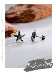 Macro view of vintage silver starfish stud earrings with detailed grainy texture finish