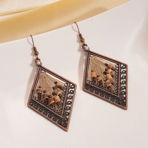 Macro detail of bohemian hollow rhombus earrings with coconut beads on a white plate