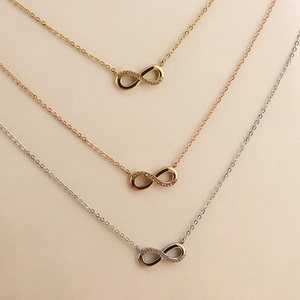 Tre collane con pendente a infinito in oro, oro rosa e argento con pietre di zircone