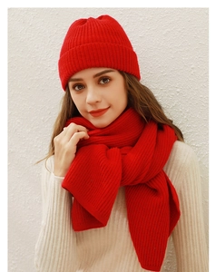 Detailaufnahme von rotem Strickmützen- und Schal-Set mit Fokus auf weiche Textur und Wärme