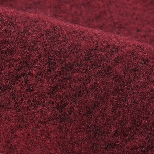 Close-up of thick dark red knit beanie fabric with soft warm wool fiber texture