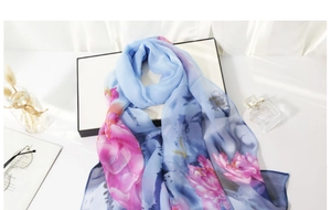Detail of thin blue silk scarf with pink lotus print showing lightweight texture
