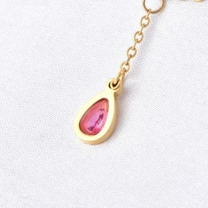 Collier doré luxueux avec pendentif en zircone rose taille poire sur tissu blanc