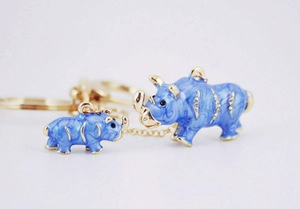Detailed close-up of blue enamel rhino charms with rhinestones and gold keychain