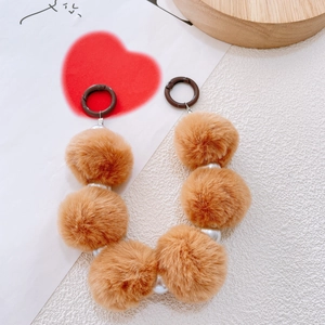 Detail of brown faux fur pom pom bag charm with silver beads and ring clip