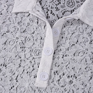 Close-up of intricate white lace fabric and matching round buttons on polo collar