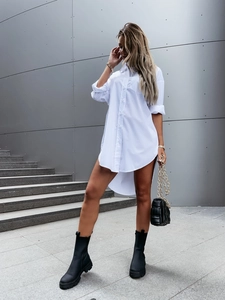 Detail of white loose-fit long sleeve button-down shirt dress with a stylish curved hemline