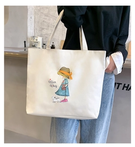 Detail view of white canvas tote bag with cartoon girl print and Nice Day lettering
