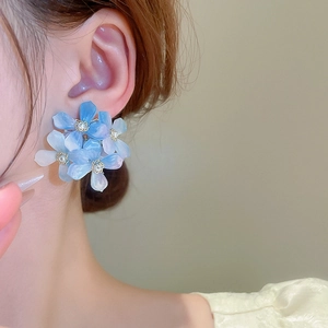 Close-up of blue gradient flower earrings on model featuring translucent acrylic petals