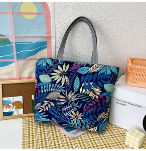 Detail of large canvas tote bag with colorful leaf prints and sturdy grey handles
