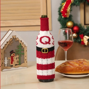 Detail of red and white striped knit wine bottle cover with Santa belt design
