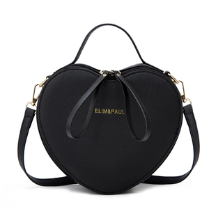Detail of heart-shaped black crossbody bag with gold hardware and cross-grain leather