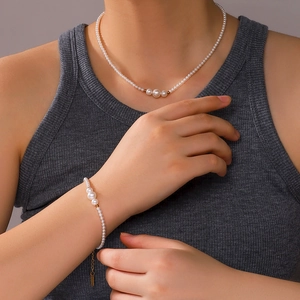 Elegant pearl necklace and bracelet set with gold beads on female model