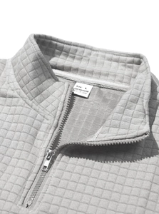 Close-up of gray half-zip sweatshirt neckline showing waffle knit texture and inner label