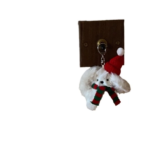 Christmas dog plush keychain with red Santa hat and striped scarf on white background