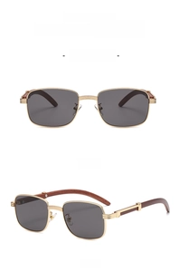 Detail view of square gold metal sunglasses with dark wood grain temples and black lenses