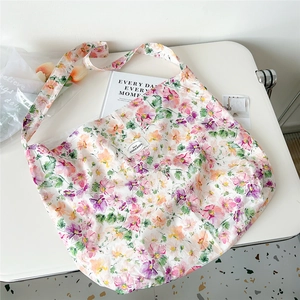 Detailed close-up of a floral oil painting canvas tote bag on a minimalist desk setting