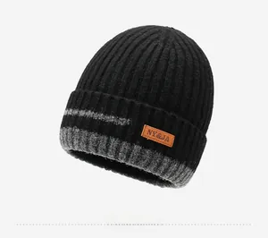 Close-up of winter knit beanie showing thick ribbing and faux leather brand patch detail
