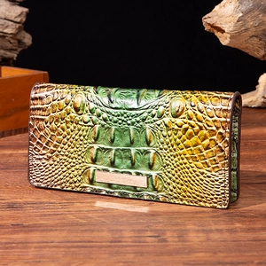 Macro detail of crocodile texture long wallet with green gold gradient on wooden surface