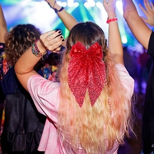 Gros plan sur la barrette nœud à paillettes rouges portée lors d'une fête festive