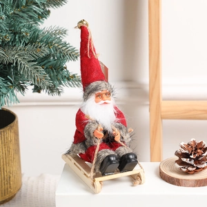 Christmas Santa Claus doll on a wooden sleigh for festive holiday tabletop decoration