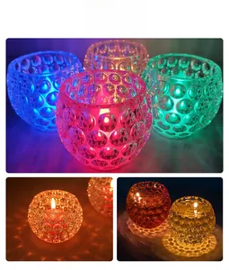 Detailed bubble textured glass candle holders in various colors with warm light reflections