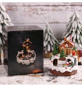 Leuchtende Weihnachtsspieluhr-Hausdekoration mit ihrer eleganten schwarzen Geschenkbox.