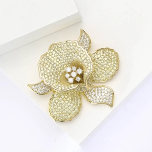 Elegant gold flower brooch with yellow cubic zirconia on white geometric background