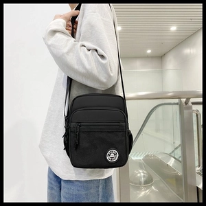 Detail of black crossbody square bag with multi-pocket design and mesh compartment