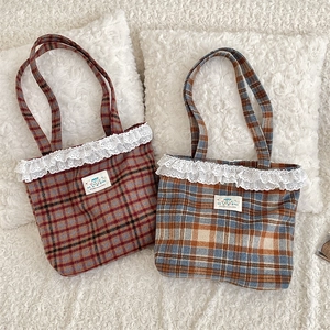 Detail of vintage plaid tote bags with delicate lace trim and happy graphic patches
