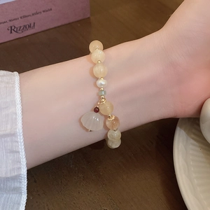 Detail view of handmade freshwater pearl and citrine beaded bracelet on female wrist