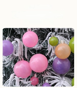 Gros plan de boules de Noël brillantes macaron suspendues sur un sapin enneigé