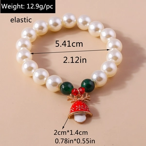 Detailed view of Christmas beaded bracelet with red bell charm and faux pearl beads
