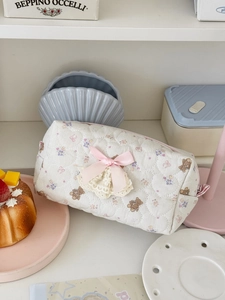 Detail of quilted bear pencil case featuring pink bow and floral embroidery textures