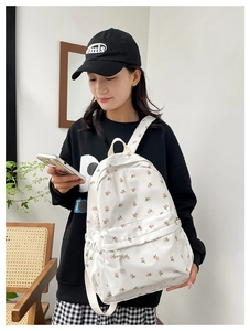Floral backpack modeled in a cozy indoor setting showing mid-size fit and daily style