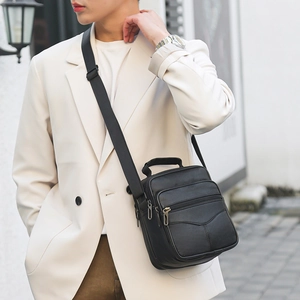 Men's black genuine leather shoulder bag worn by model in a business casual style