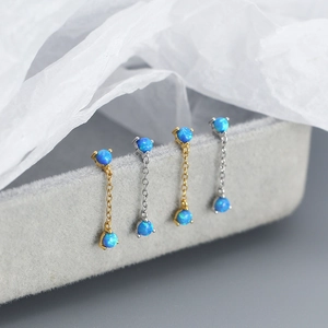 Detailed macro view of 925 sterling silver tassel earrings with blue opal gemstones in a box