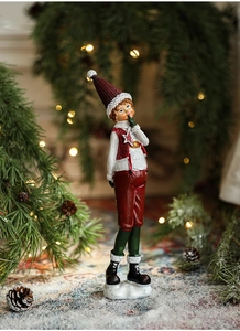 Detail of Christmas boy figurine with hand-painted resin finish and festive holiday colors