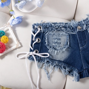 Dettagli di pantaloncini di denim blu scuro con lacci laterali e bordi sfilacciati