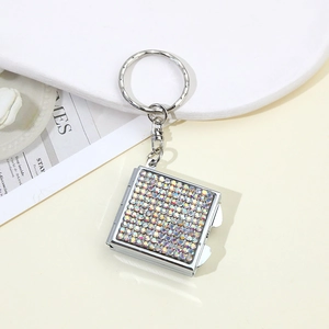 Detail of silver square rhinestone keychain with polished crystals on a minimal background