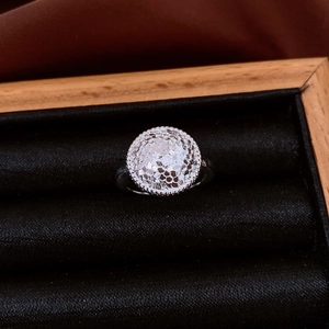 Vue détaillée de la bague circulaire argentée alvéolée dans un écrin en bois