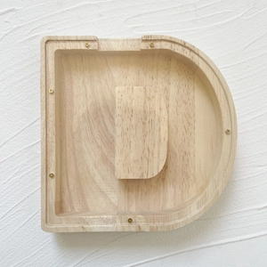 Detail view of letter D wooden piggy bank with clear acrylic panel and visible wood grain