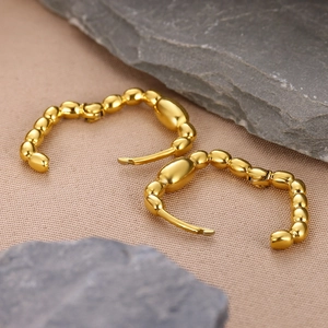 Minimalist 18K gold-plated beaded linear hoop earrings on a natural stone background