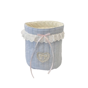 Blue and white seersucker quilted storage basket with lace trim and pink bow accent